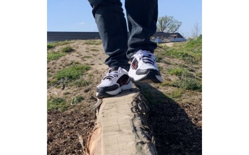 A close up of feet balancing on a tree trunk