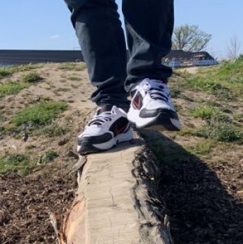 A close up of feet balancing on a tree trunk