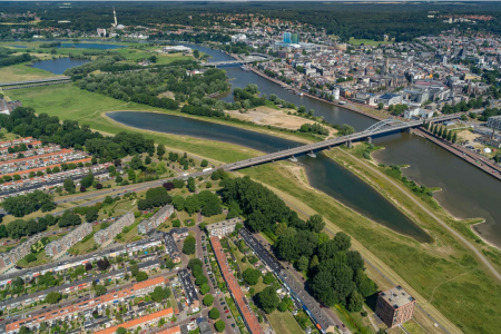 Gelderse Poort, showing an area of grassland and water between the river and built up area.
