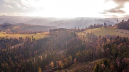 A European landscaoe with wooded slopes and mountains beyond.