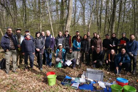 A group photograph of workshop participants standing in a forest.