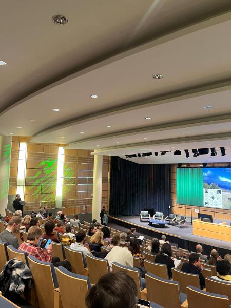 People seated in a lecture theatre watching a presentation.