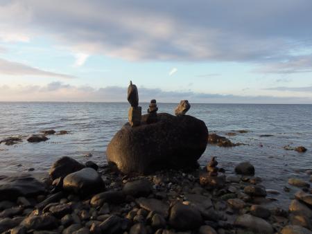 image of rocks on a sandy beach, tide out, sunset