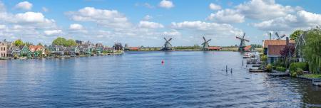 Houses and windmills along a river in Zaanstad, province of North Holland