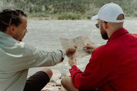 Two people looking at a map by the river