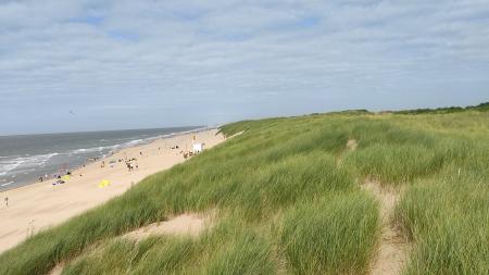 A view of a coastal dune near Ostende in Belgium. The narrow coastal space is shared between the coastal dune and people using the beach for recreation.