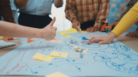 brainstorming stock image of people working on a colourful mind map together