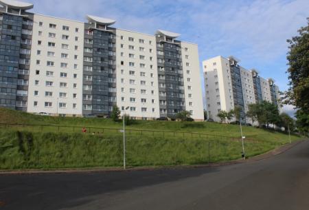 A sloped and grassed area in front of tenament buildings.