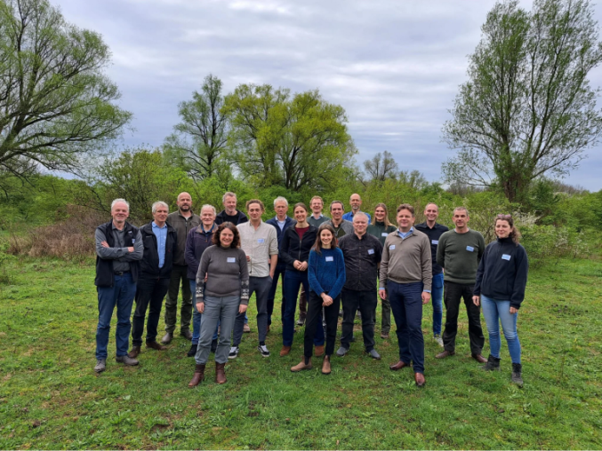 A group of wildE workshop participants standing in an area of greenspace and trees.