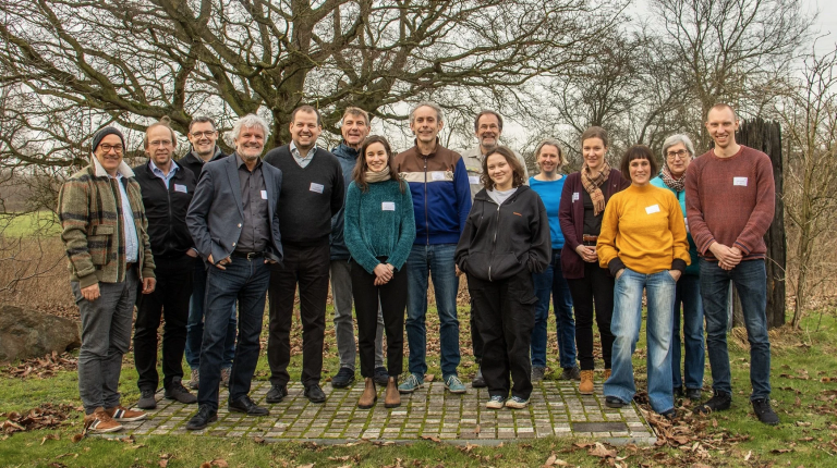 The wildE project team standing in a landscape in the Rhur area, there are trees behind the group.