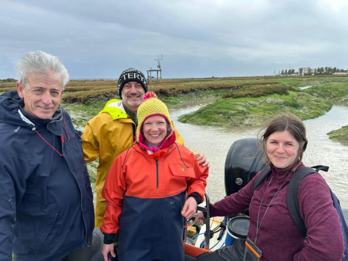Four people stood in sand dunes in Cadiz smiling at the camera.