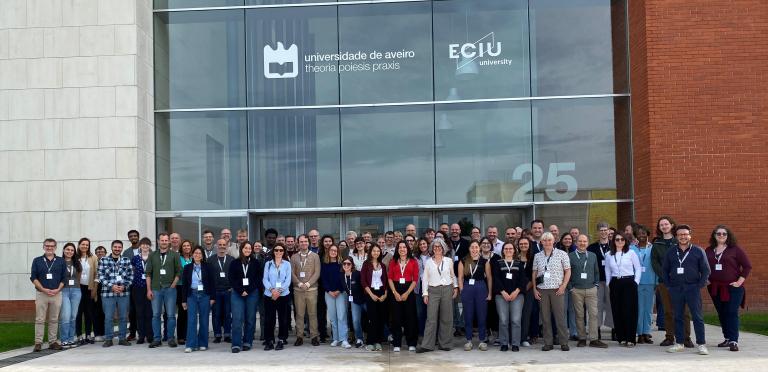 Rewrite consortium members standing outside a building.