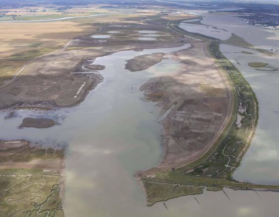 Inundated coastal landscape with open flat land, small islands and ocean.
