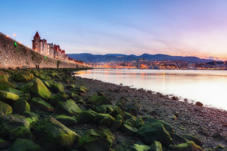The Getxo coastline with historic buildings and wall on the shore.