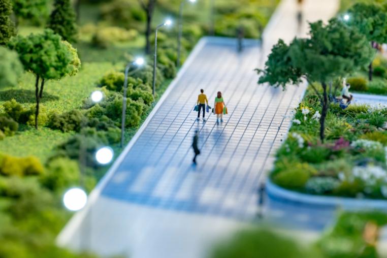 architecture model of people walking through green space