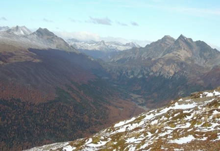 An upland mountain landscape with sharp ridges and steep slopes, the lower slopes and lightly forested.